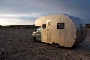 Sir James a handmade campervan available to rent on a beach as the sunsets