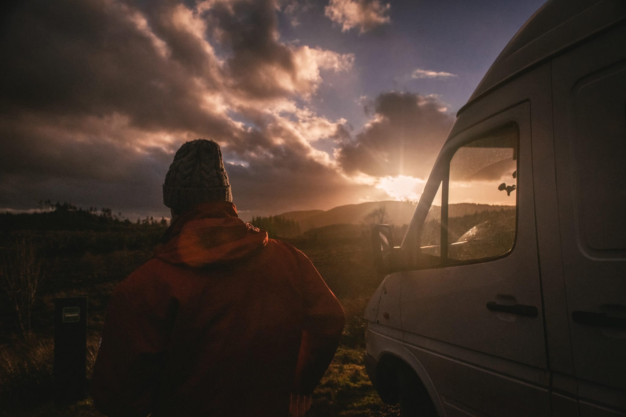 A man with his campervan as the sun sets