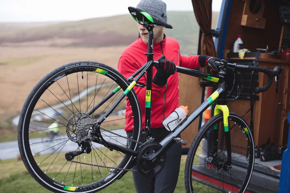 A man putting a bike into a campervan in wales