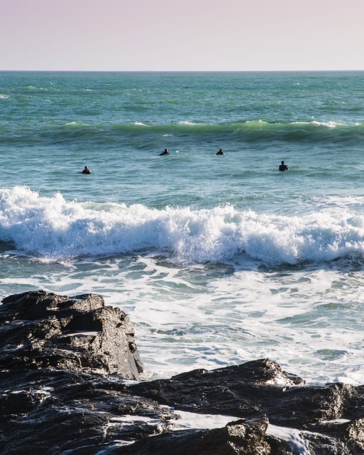 Surfers at Poldhu cove, Cornwall, whilst travelling in Baxter the Quirky Camper. Hire him at https://www.quirkycampers.com/uk/campervans/devon/exeter-devon/baxter/