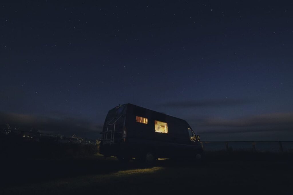 a campervan with its lights on in the darkness