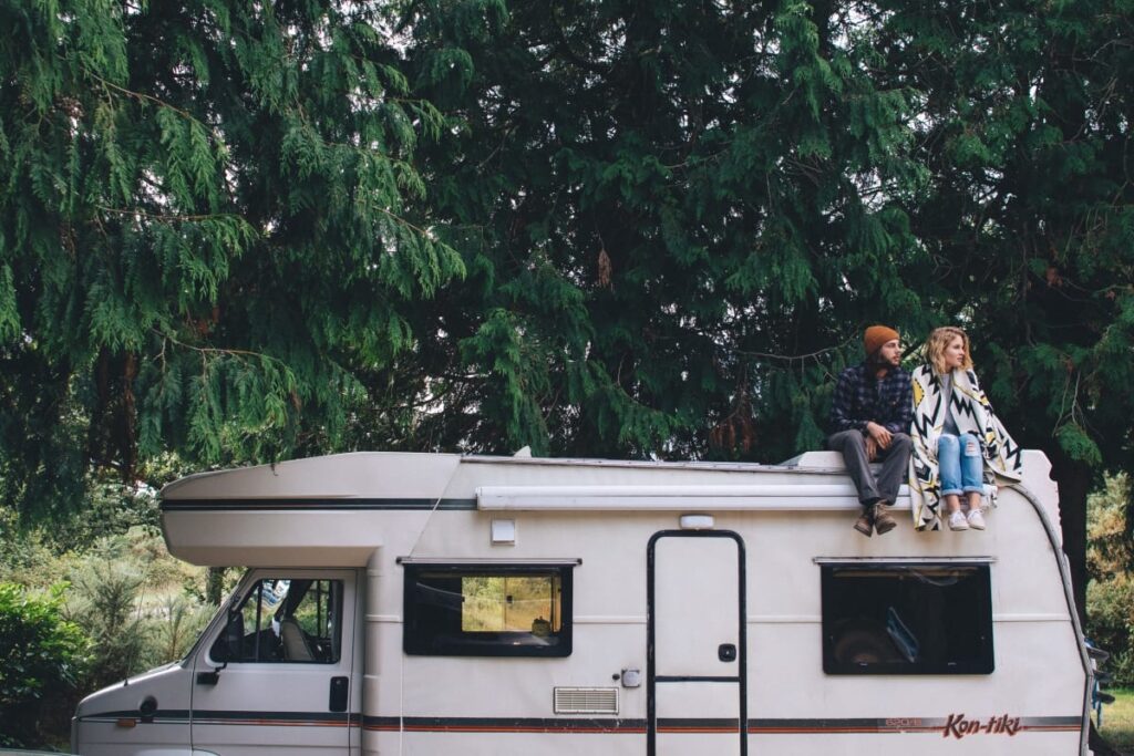 A couple sat on the roof of Tiki, Quirky Campers' retro campervan. Hire her at https://www.quirkycampers.com/uk/campervans/dorset/poole-dorset/tiki/ 