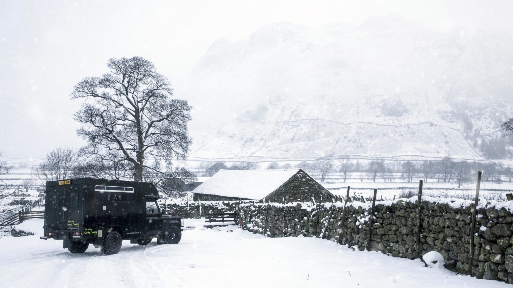 a campervan in the snowy british countryside on an adventure holiday in UK