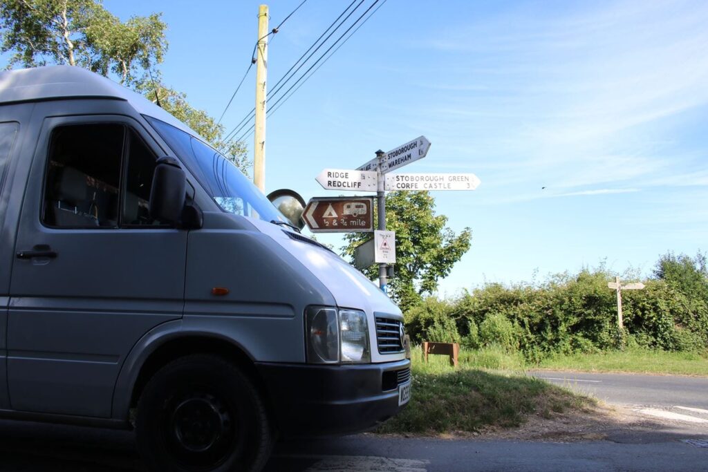 The front of a campervan at a crossroads on a country lane