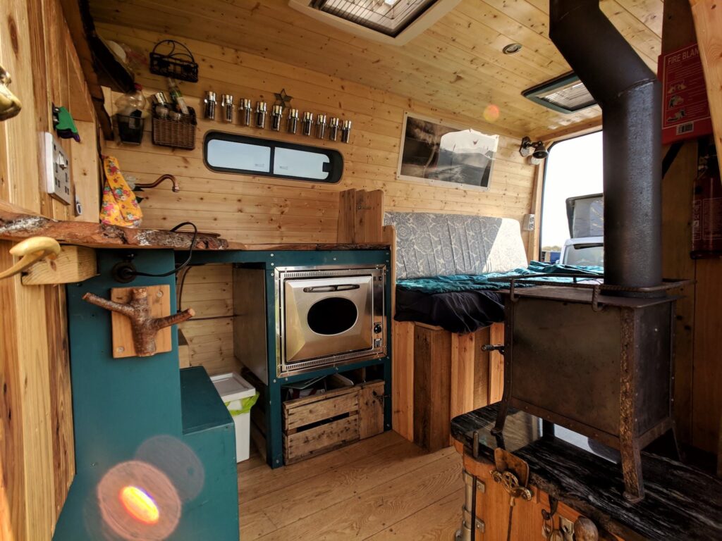 The inside of a self built campervan including oven, wood burner and spice racks