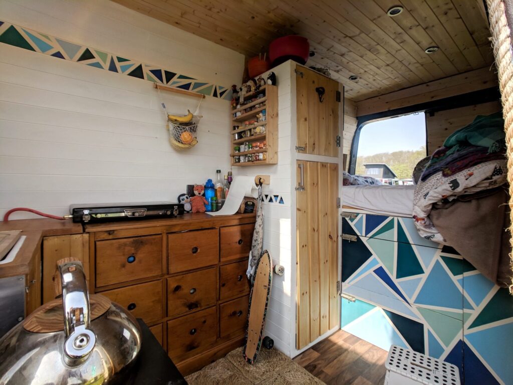 The inside of a selfbuilt campervan with a lot of storage drawers