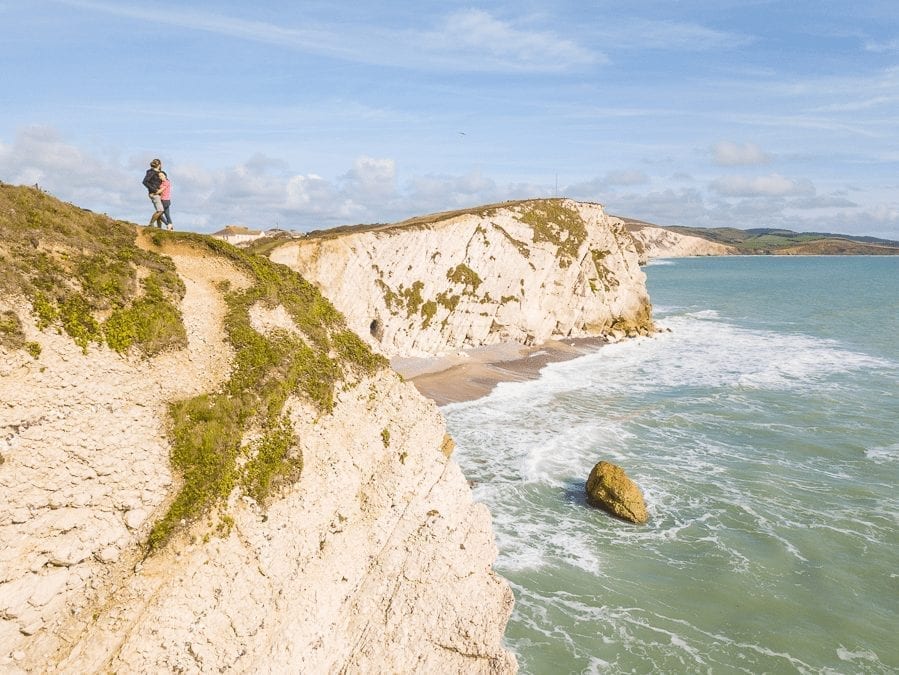 cliffs in the UK with the sea below and two americans looking into the distance