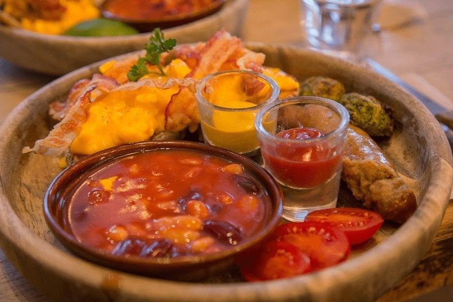 British cuisine a plate of eggs, beans, tomotoes, sausages and mustard and ketchup