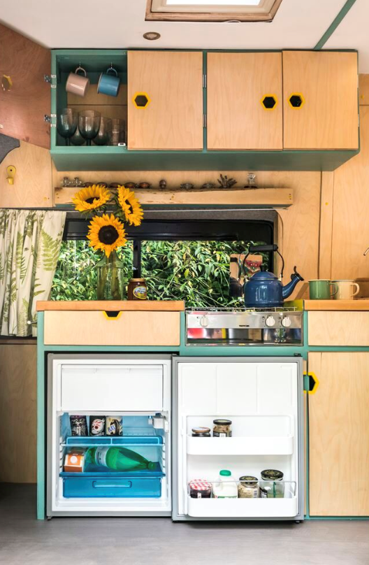 A spacious kitchen with large fridge in a campervan conversion