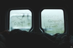 Windows of a campervan with condensaion where a love heart, Skye and @quirky campers Emma have been written out by fingers