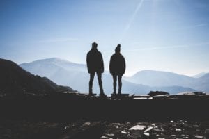 A couple's silhouette looking over mountains 