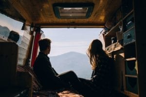 A couple sat in the back of their selfmade quirky campervan on their honeymoon