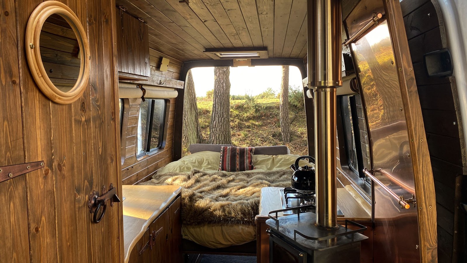 Cosy wooded campervan scene with woodburner. 