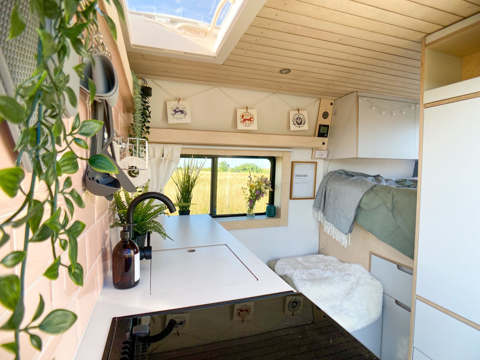 Modern white wooden campervan interior with plants. 