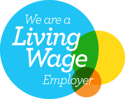 The image features a logo consisting of overlapping circles. The largest circle is blue with the text "We are a Living Wage Employer" in white. Smaller circles in green, yellow, and orange overlap partially at the bottom right, signifying commitment to fair wages.