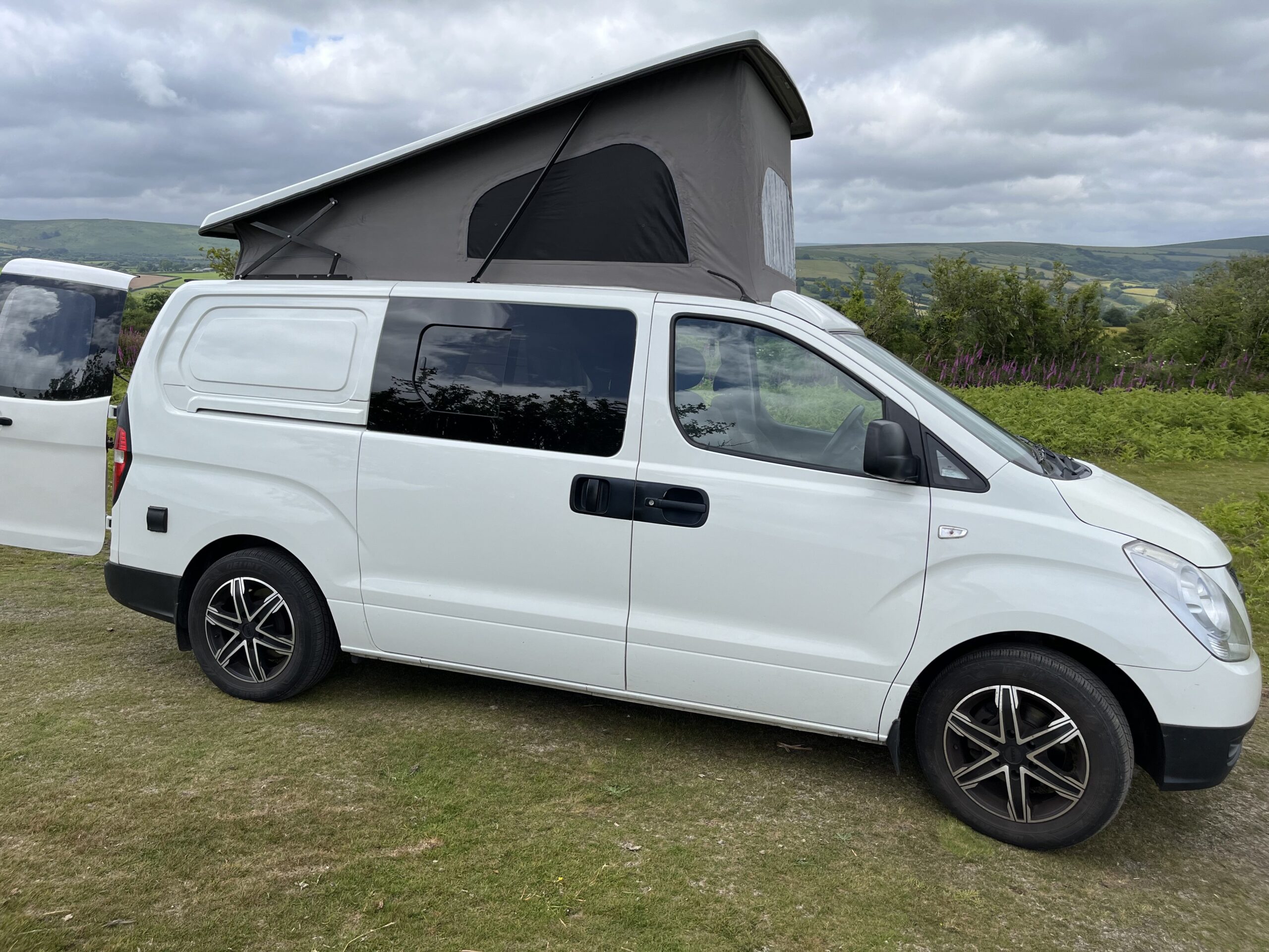 a pop top on a campervan in the countryside